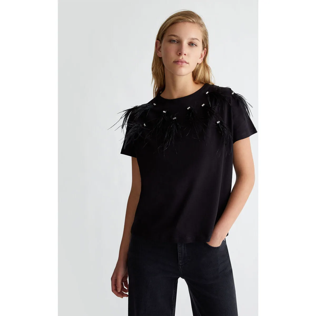 Camiseta con plumas decorativas