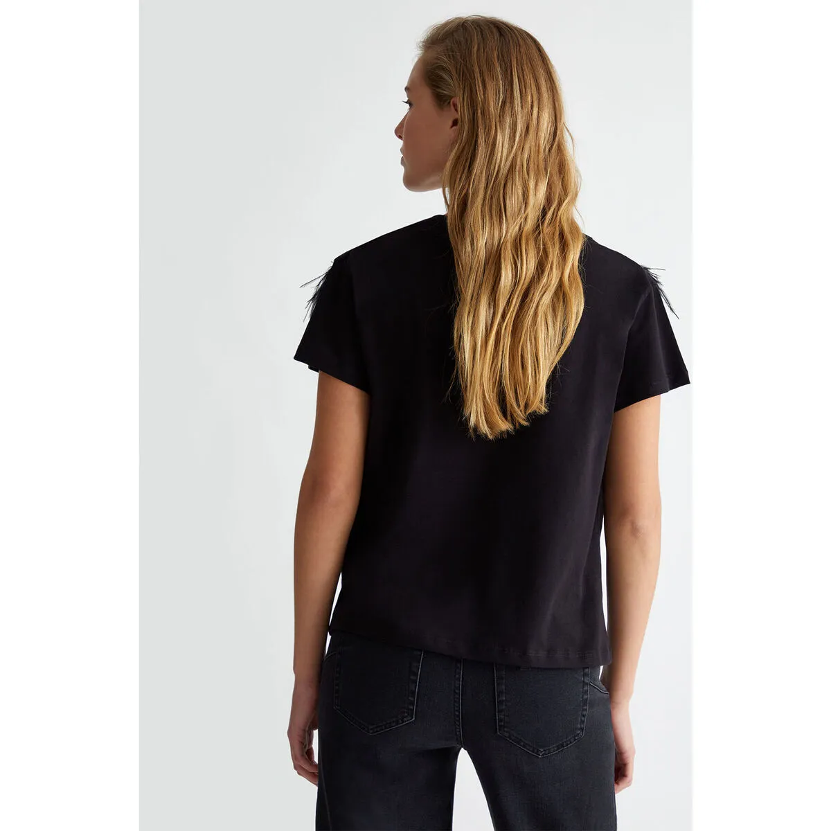 Camiseta con plumas decorativas