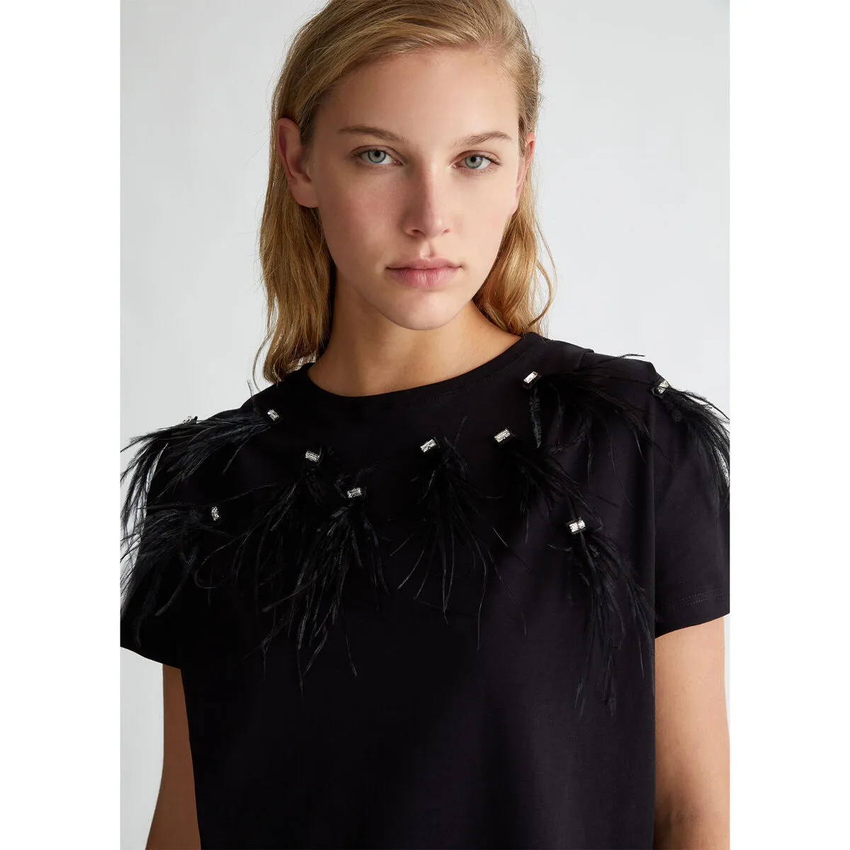 Camiseta con plumas decorativas
