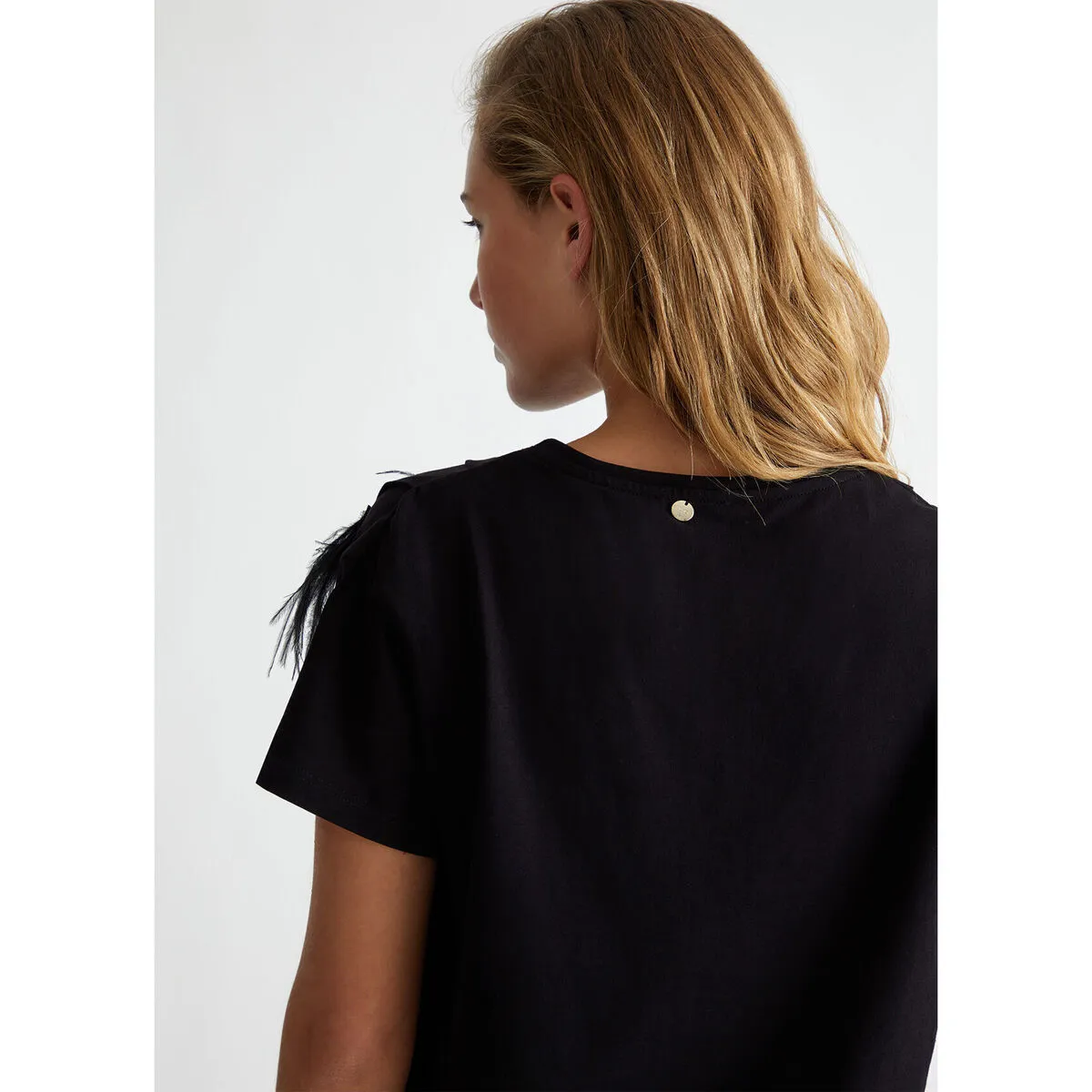 Camiseta con plumas decorativas